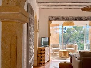 a living room with a tv and a couch and chairs at Villa Granadella in Jávea