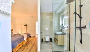 a bedroom with a bed and a bathroom with a shower at Villa Granadella in Jávea +37 photos