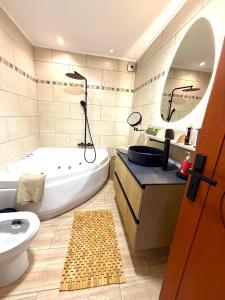 a bathroom with a tub and a toilet and a sink at Casa Blue in Panayía Mesosporítissa