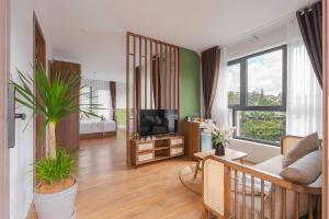 a living room with a couch and a tv at Nature Hotel - Le Hong Phong in Da Lat