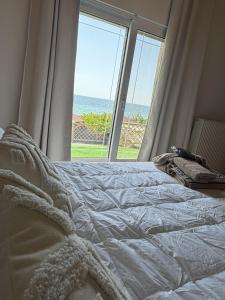 a bedroom with a bed with a view of the ocean at Casa Blue in Panayía Mesosporítissa