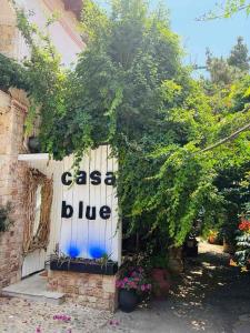 a white garage door with the words case dye on it at Casa Blue in Panayía Mesosporítissa +33 photos