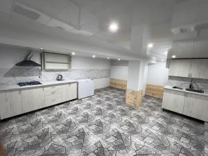 a large kitchen with white cabinets and a stone floor at Ohanavan Garden Guesthouse in Oganavan