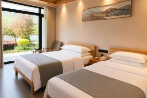 a hotel room with two beds and a window at Houshan Park House in Narat