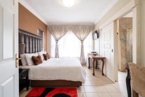 a bedroom with a large bed and a window at Siyajabula Guesthouse in Howick +34 photos