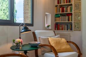 a living room with a table and a chair and a book shelf at Villa Caterina 8, Emma Villas in San Gimignano