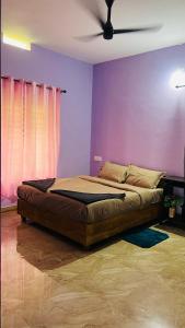 a bed in a room with a purple wall at Moonlight mist wayanad in Vaduvanchal