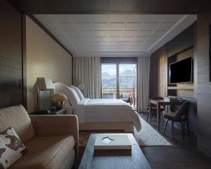 a hotel room with a bed and a living room at Four Seasons Resort Megève in Megève +23 photos