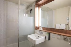 a bathroom with a sink and a shower and a mirror at Campanile Evry Ouest - Corbeil Essonnes in Corbeil-Essonnes +77 photos