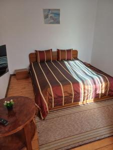 a bed with a wooden frame in a bedroom at Кацарила in Gabrovo