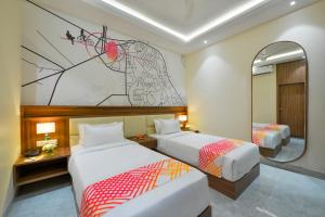 a hotel room with two beds and a mirror at Ginger Gadchiroli in Garhchiroli +18 photos