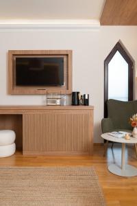 a living room with a television on a wall at OLEO hotel in Momchilgrad