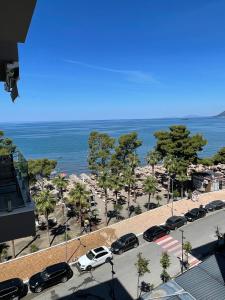 a parking lot with cars parked next to the ocean at Dolce Mare Luxury Apartment in Shëngjin