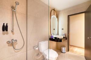 a bathroom with a shower and a toilet and a sink at Fox Hotel Nagoya Batam in Nagoya