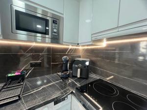 a kitchen with a counter top with a microwave at BENILOVE en playa VUE MER Panoramique in Benidorm