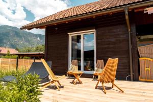 a group of chairs sitting on a wooden deck at S´Holzhäusle in Döbriach +25 photos