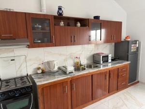a kitchen with wooden cabinets and a sink and a microwave at MeloMar Rooms in Ponta do Sol +50 photos