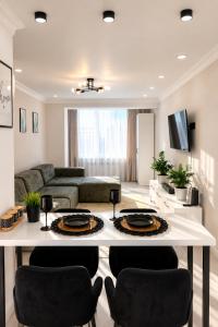 a living room with a white table and chairs at Sunset Apartment Aktau Квартира в центре у моря in Aktau