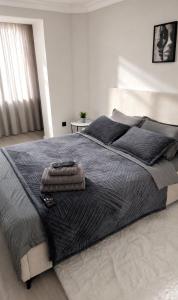 a bedroom with a large bed with a black blanket at Sunset Apartment Aktau Квартира в центре у моря in Aktau