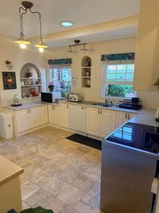 a large kitchen with white cabinets and tile floors at Echo Point Cottage in Katoomba