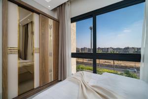 a bedroom with a bed and a large window at Luxury Smart Home Entire Apartment with 2 Bedrooms in Madinaty in Madinaty +66 photos