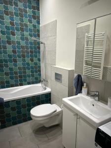 a bathroom with a toilet and a tub and a sink at Léna's apartman in Pécs