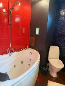a bathroom with a white tub and a toilet at Aiavilja Red Pearl Apartment in Paide +12 photos