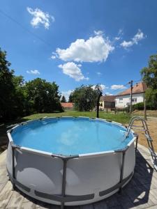 a hot tub in a yard with a blue sky at Dióliget Apartman - free e-bikes in Orfű