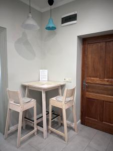 a table and two chairs and a table and a door at Léna's apartman in Pécs