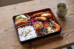 a tray of sushi and rice on a wooden table at SEN RETREAT HONGU - Kumano Kodo Gateway in Tanabe