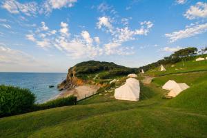 a group of tents on a hill next to the ocean at Kampaoh Las Arenas in Pechón +65 photos