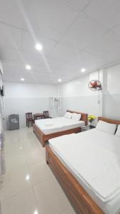 a room with two beds and a table and chairs at Hai Phuong Tuyen Guesthouse in Phú Quốc