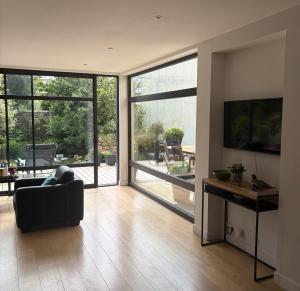 a living room with a couch and a tv and sliding glass doors at Ty-Aganisia Breizh in Perros-Guirec