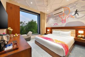 a bedroom with a bed and a large window at Ginger Gadchiroli in Garhchiroli