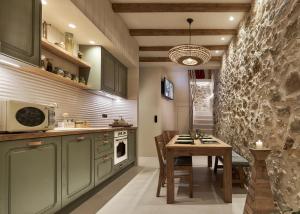 a kitchen with green cabinets and a table with chairs at Diastar Boutique in Heraklio