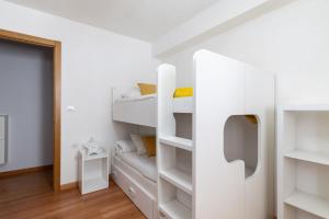 a bedroom with white bunk beds and a doorway at Apartamento familiar acogedor in Ordes +20 photos