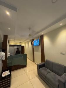 a living room with a couch and a tv at Regal residency in Perintalmanna