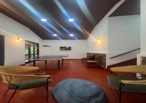 a room with a ping pong table and chairs at The Nook in Deraniyagala