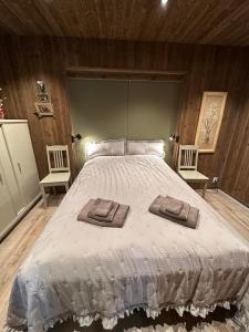 a bedroom with a large bed with two towels on it at Architectural gem with fjord view in Holmedal
