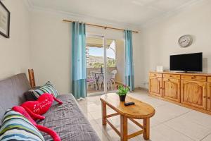 a living room with a couch and a tv and a table at Los Cristianos Plaza Centre suite in Los Cristianos