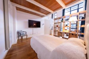 a bedroom with a bed and a chair and a tv at La Maison del Capestrano in Milan +67 photos