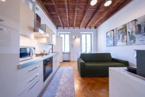 a kitchen with a green couch in a room at La Maison del Capestrano in Milan