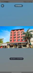 a picture of a red building with a palm tree at Hotel Sonali Regency in Bhopal