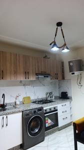 a kitchen with a stove and a washing machine at Lux New Apartment in Mrhila +9 photos