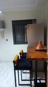 a kitchen with a wooden table and some chairs at Lux New Apartment in Mrhila