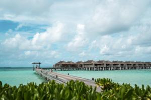 a pier with overwater bungalows in the water at Constance Moofushi Maldives - All Inclusive in Himandhoo 