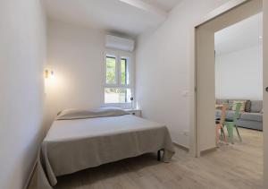 a white bedroom with a bed and a window at Sansone Sul Mare Appartamenti in Portoferraio +27 photos