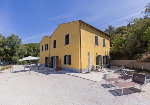 a yellow building with tables and umbrellas in front of it at Sansone Sul Mare Appartamenti in Portoferraio