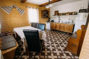 a kitchen with a table and chairs and a refrigerator at Cabana Todireni Vatra Dornei in Vatra Dornei