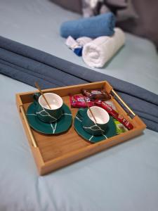 a tray with two cups and saucers with chopsticks at Jacaranda Bnb in Khayelitsha